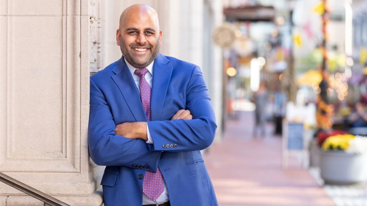 Connecticut mayor Arunan Arulampalam smiles in a suit.