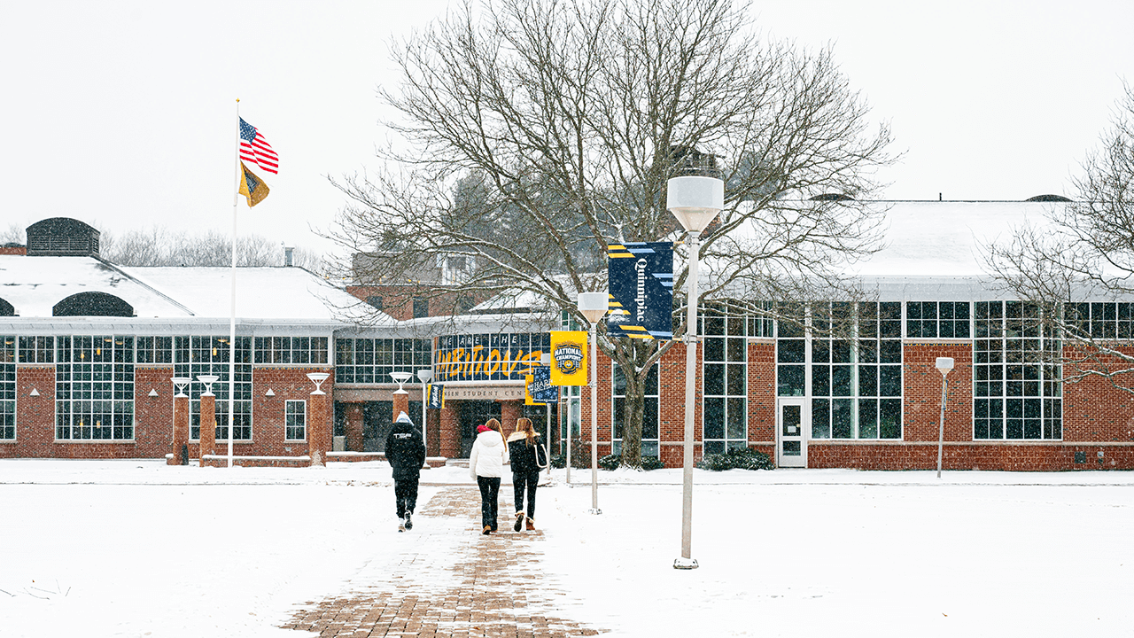 Students walking on the Mount Carmel Campus and Quadrangle while it snows
