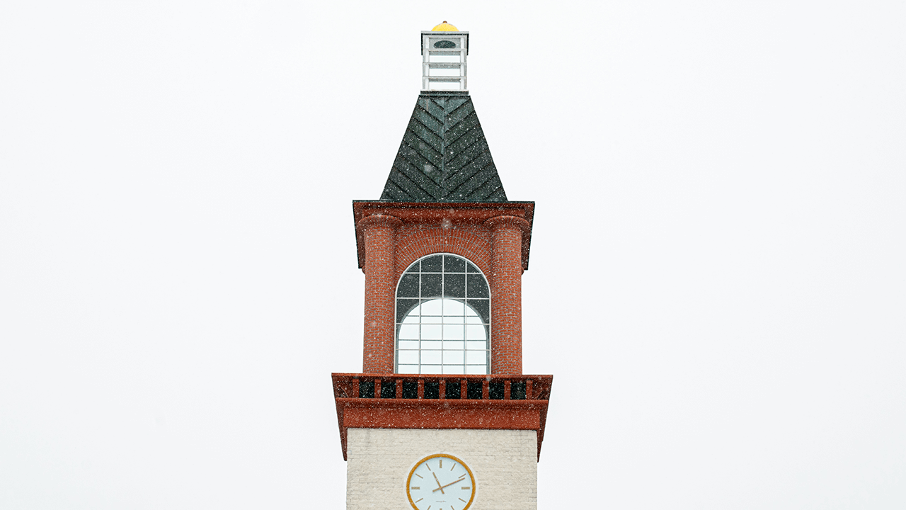 An up-close architecture shot of the clock tower at Quinnipiac University.