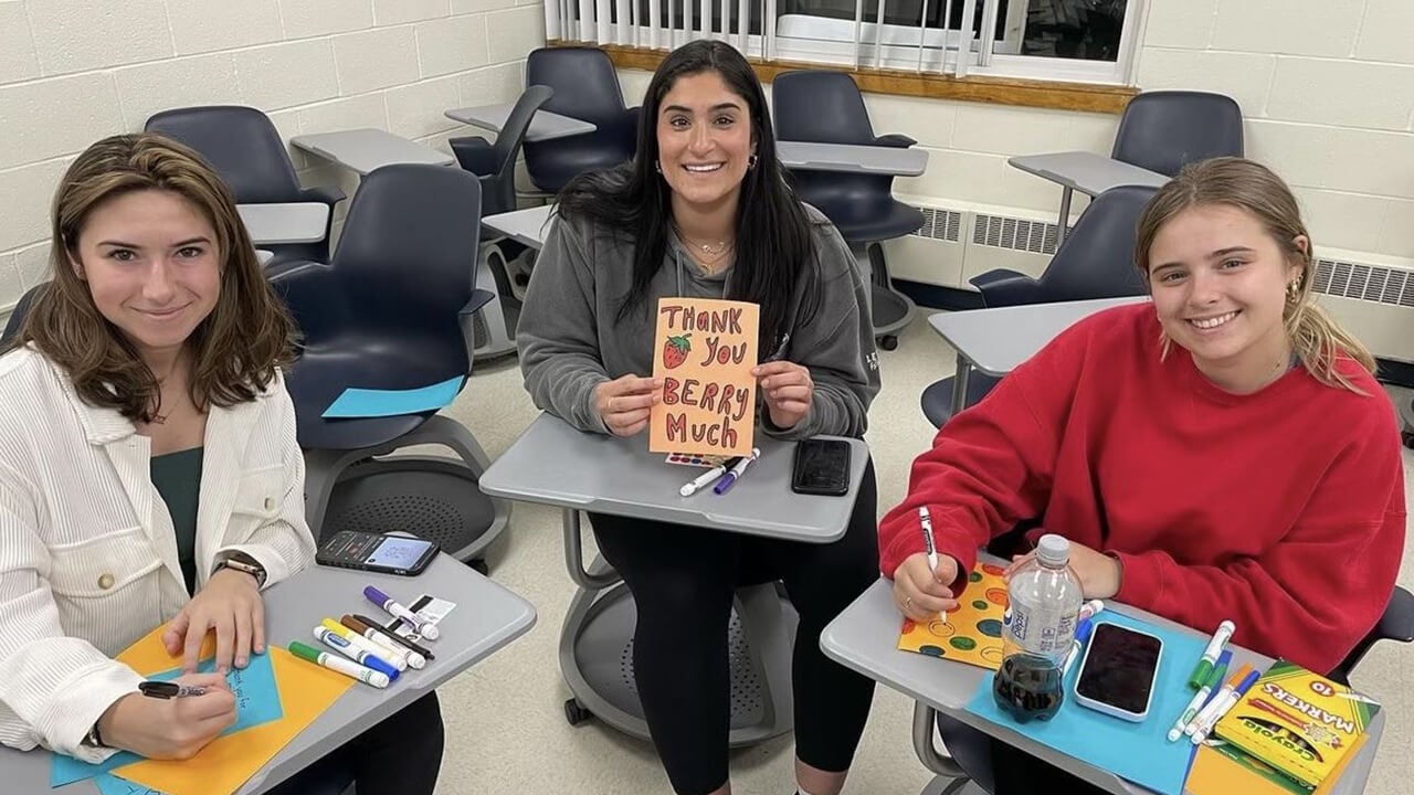 Students creating handmade cards in a classroom for Cards for Care QU