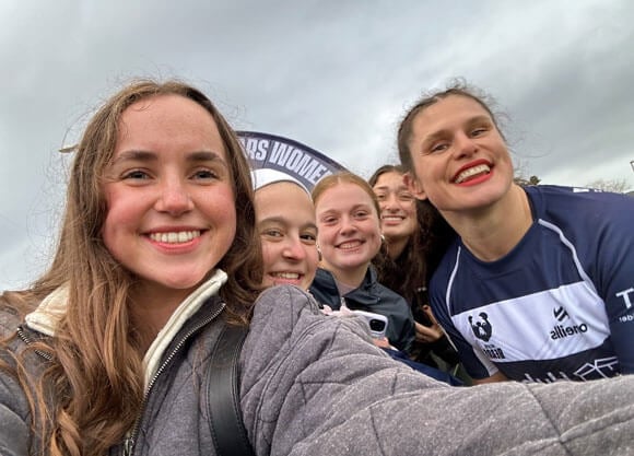 Students take a selfie with alumna and olympian, Ilona Maher.