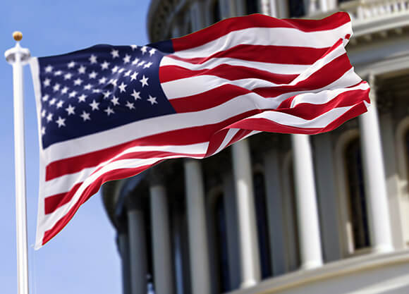 The U.S. flag flies in front of the U.S. Capitol