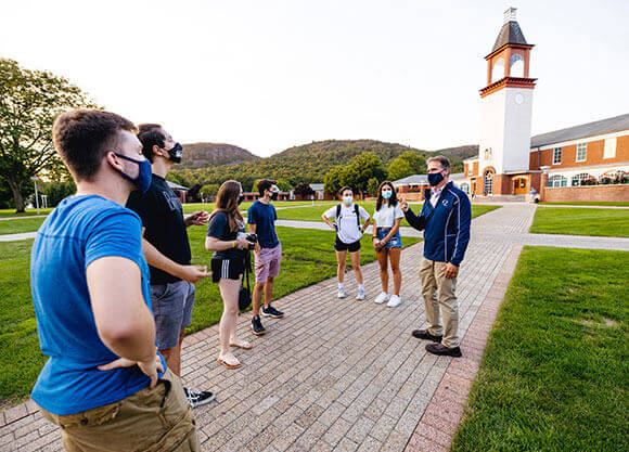 Shot of Tom Ellett talking to students on the quad