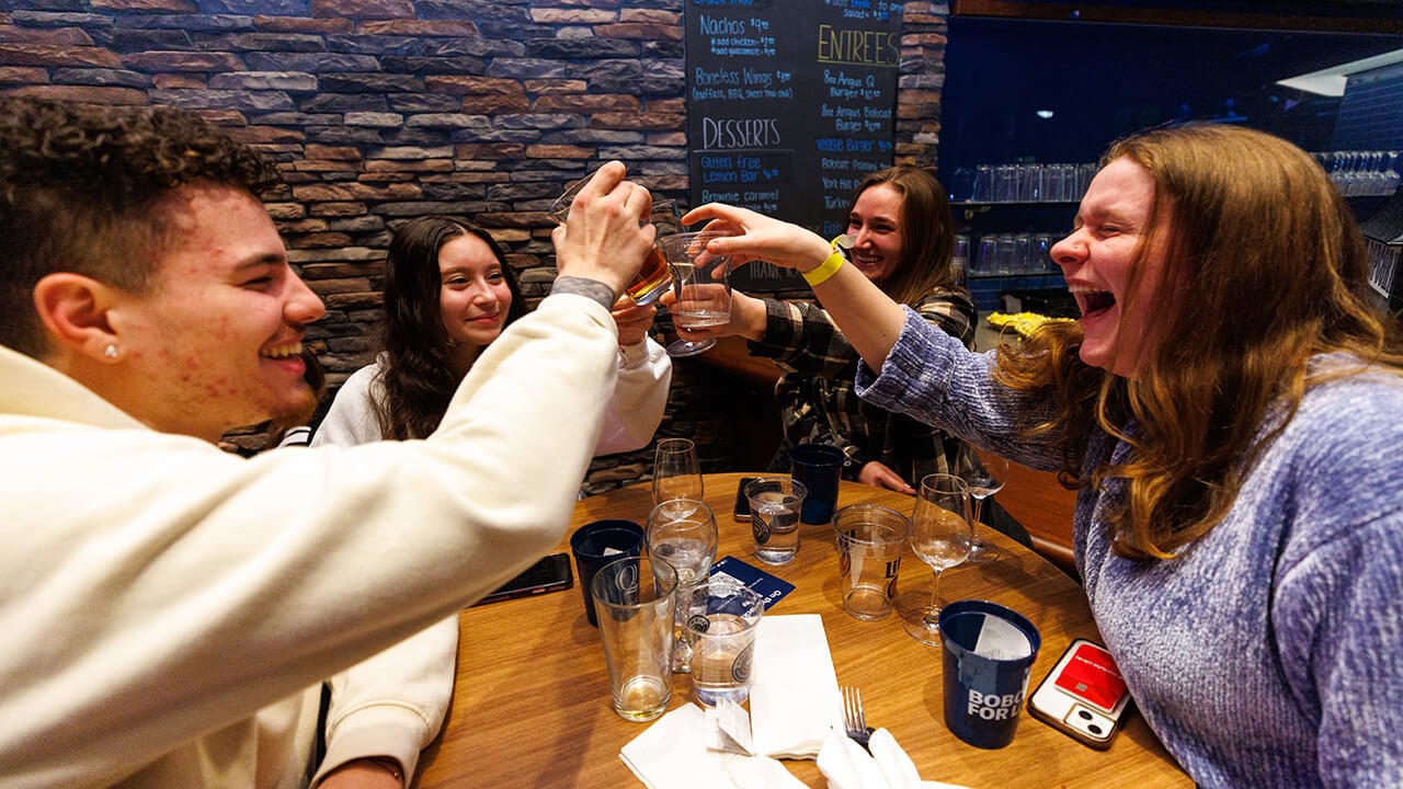 Students enjoying drinks together at the campus pub and grill