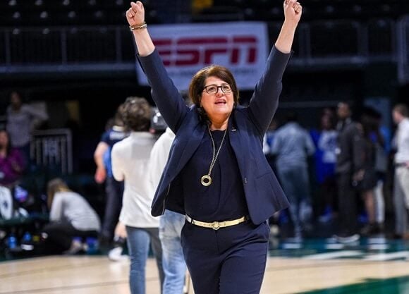 Fabbri raises her arms in celebration on the basketball court