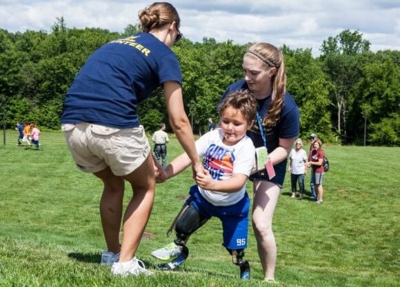 QU grad students help child up a hill