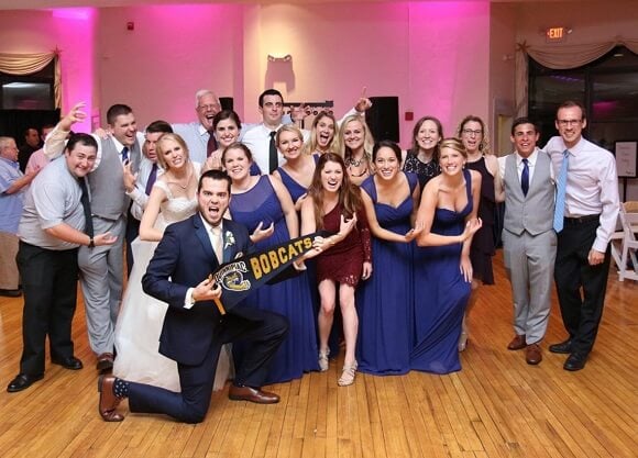 Alumni hold up a Bobcats sign at the reception.