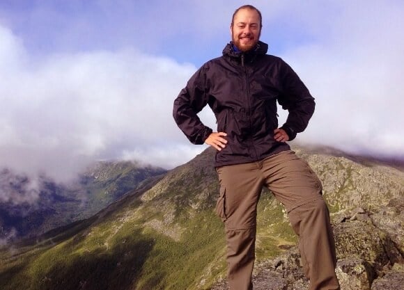 Warden stands atop a mountain.