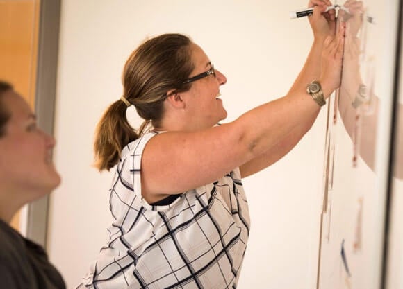 New Haven middle school teacher Heather Toothaker writing on whiteboard