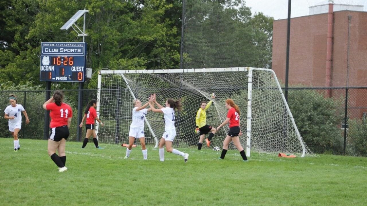 Quinnipiac soccer players high-fiving after scoring a goal