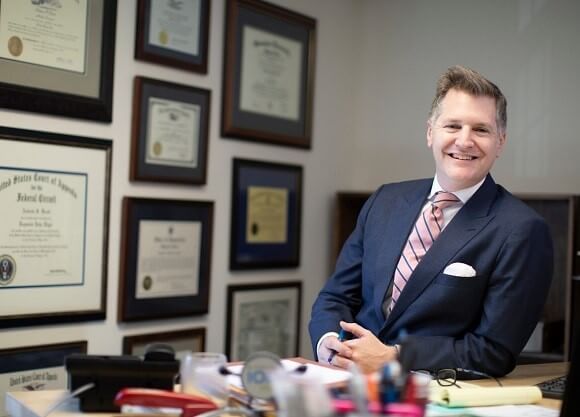 Andrew Knott sits behind desk at the law firm Knott & Knott, LLC.