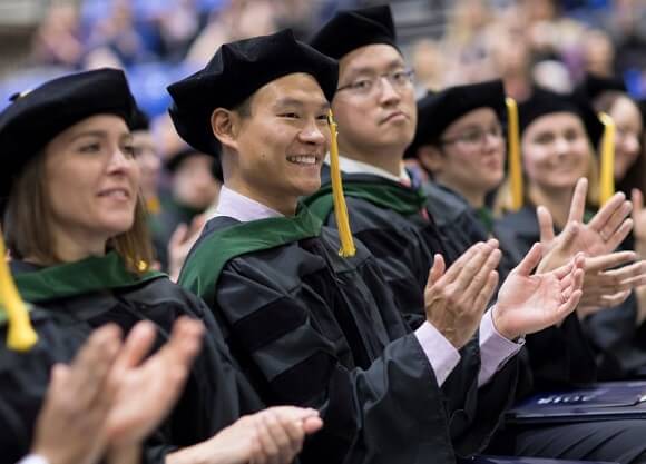 Medical students stand during a commencement ceremony