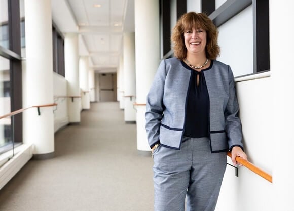 O'Connor stands in a hallway of the School of Nursing, with her hand on a railing.