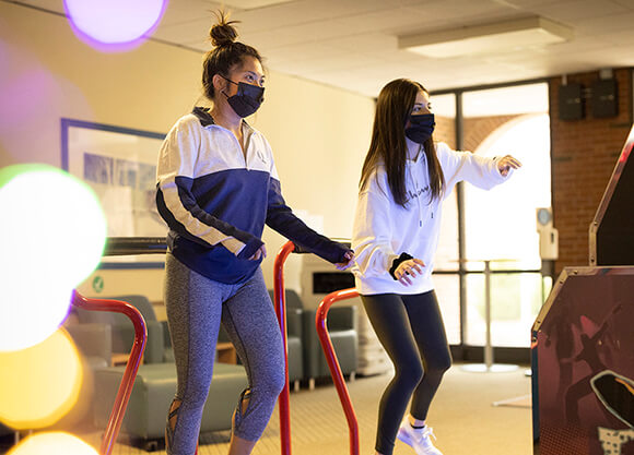 Two women play a video game.