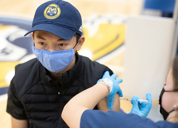 A student receives a COVID-19 vaccine.