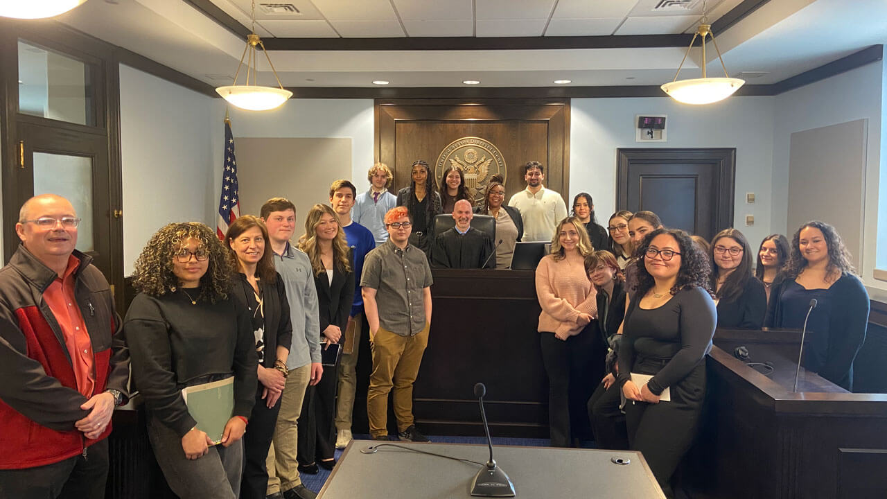Students stand in the court house with Judge M. Spector