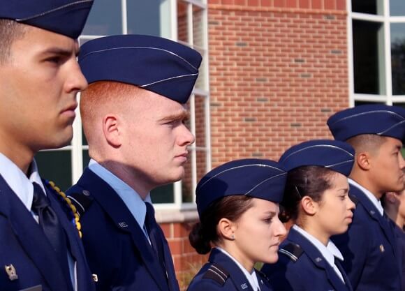 Veterans stand in a line in their military garb.