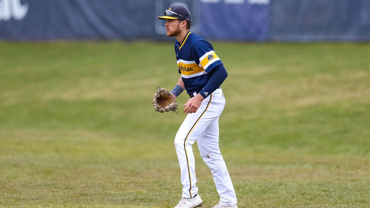 Man standing on the baseball field in uniform prepared to catch ball