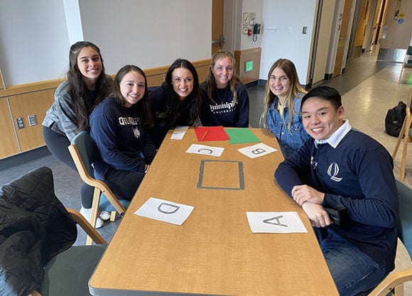 Students gather around a table