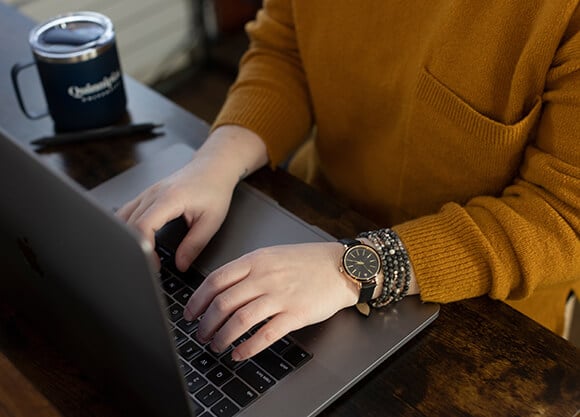 A woman types on a laptop.