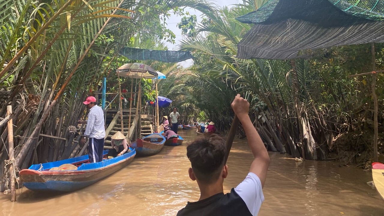 Quinnipiac business class being guided in the water on canoes