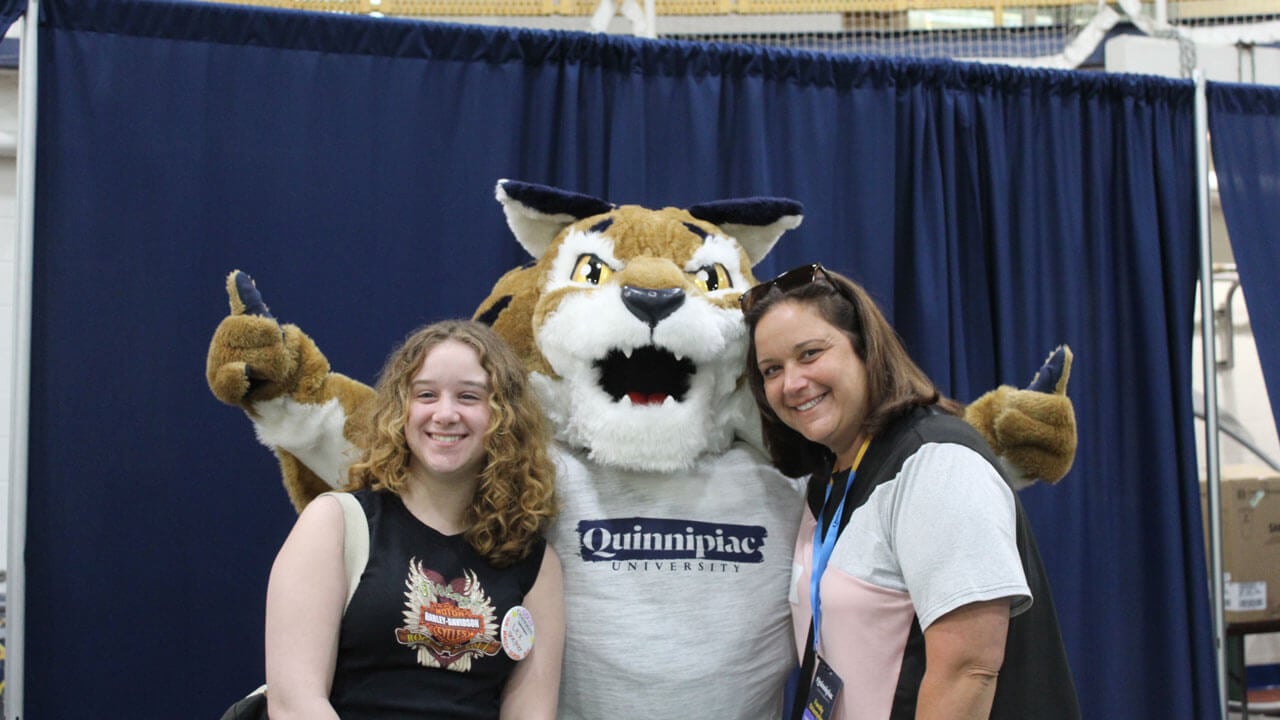 Boomer the Bobcat giving a thumbs up with a family