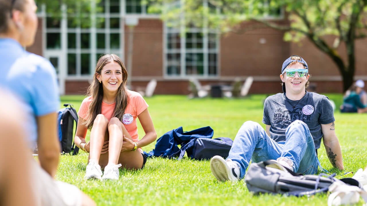 first-year students laughing and sitting on the quad for Orientation