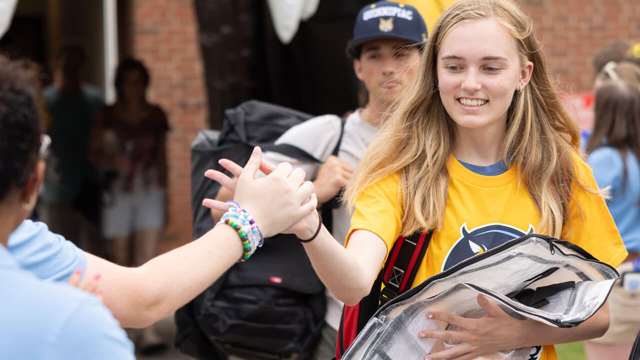 Incoming student giving a high-five to Orientation Leader