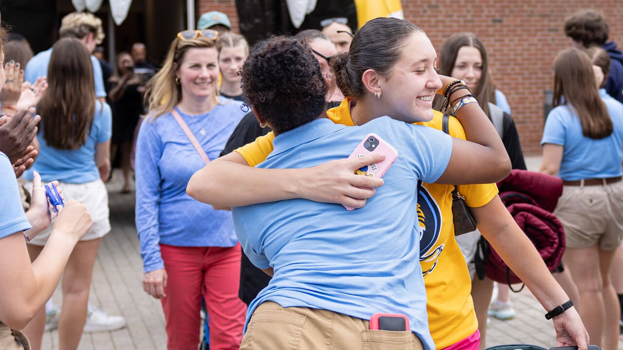 Quinnipiac first-year hugging their orientation leader