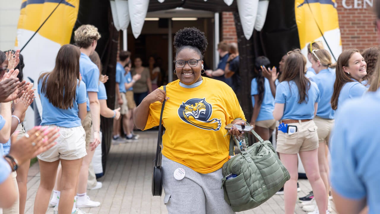 First-year student smiling and walking out of RecWell