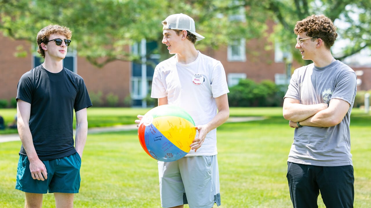 Students talk while holding a beach ball