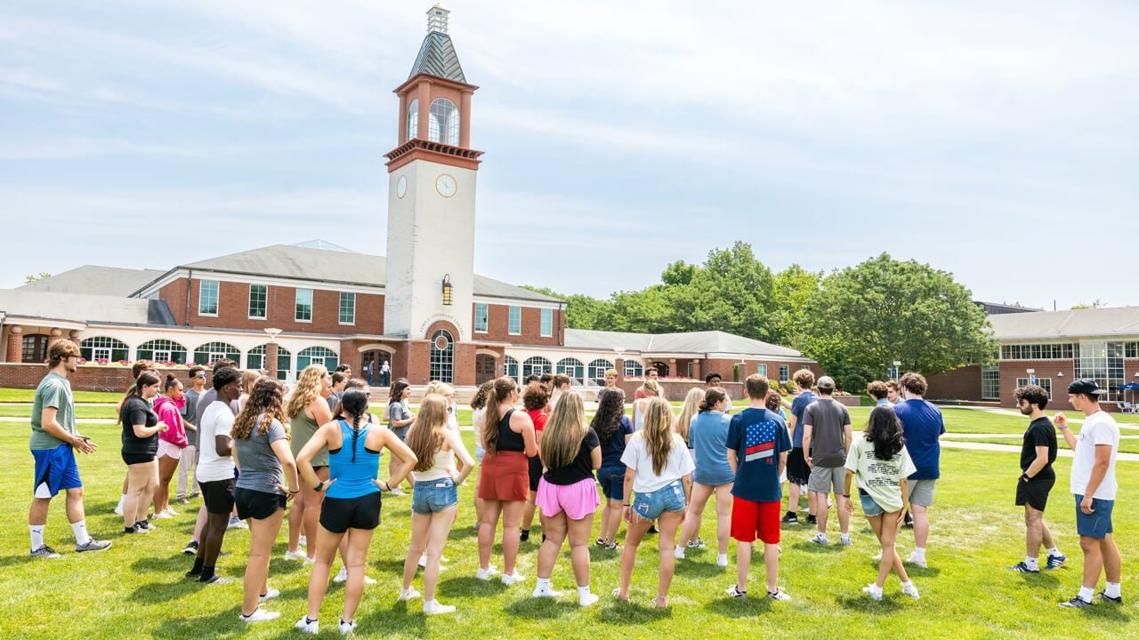 Students stand in a group in front of the clocktower
