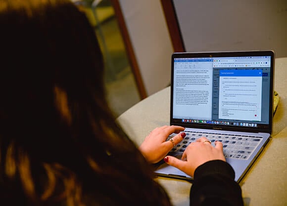 A student works on her computer at the Learning Commons