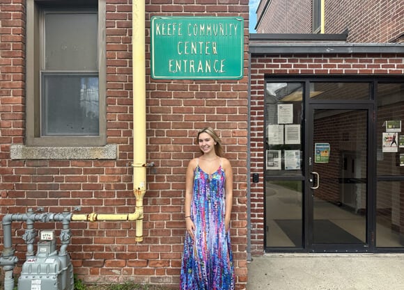 Jessica VanOss stands in front of Keefe Community Center sign