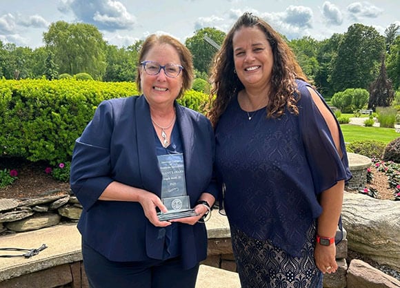 Professor Angela Mattie holds an award