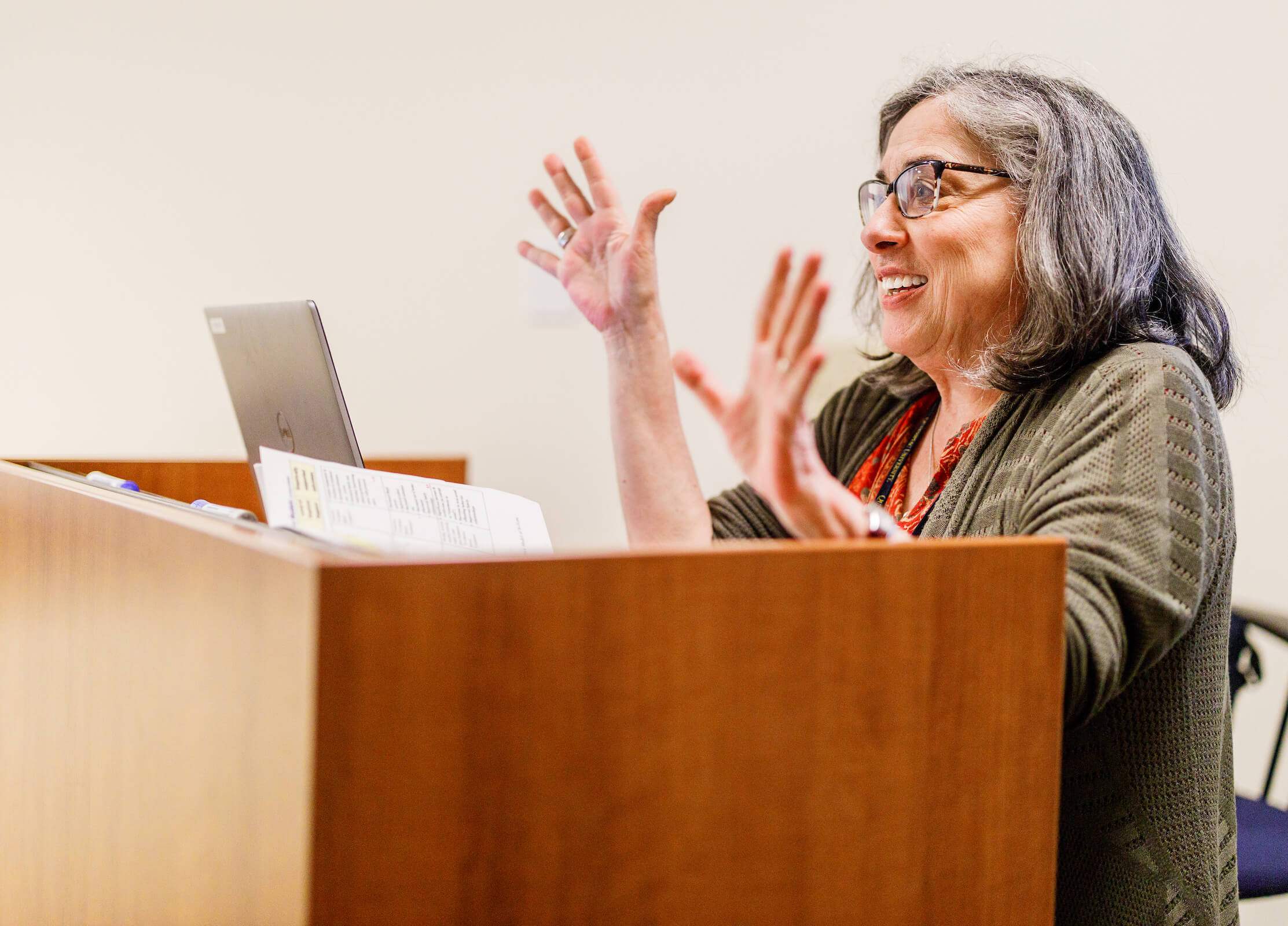 Faculty member Laura Mutrie behind a podium talking