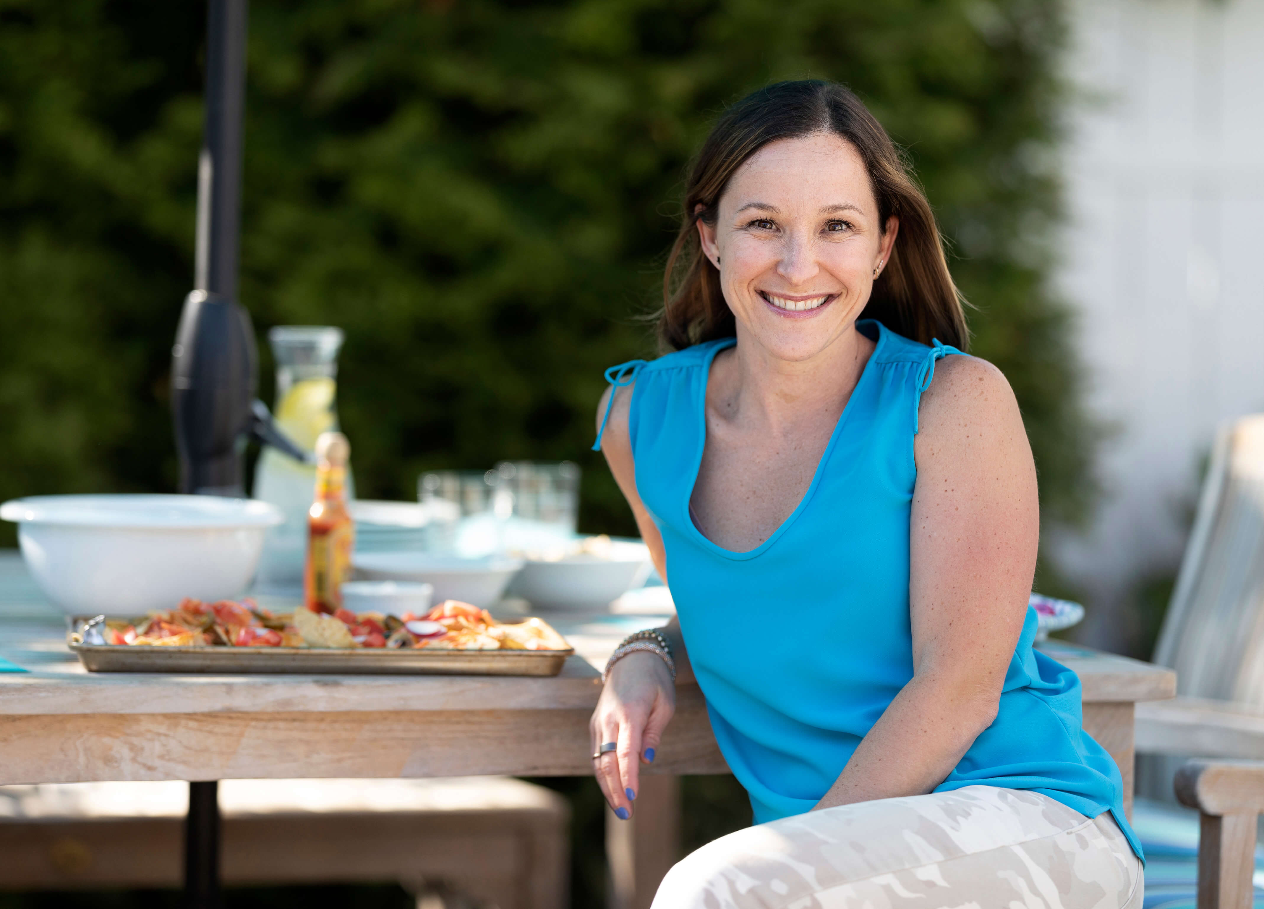 Professor Dana White posing on a picnic bench with food in the background