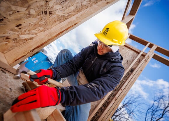 Student building a house outside for habitat for huamnity