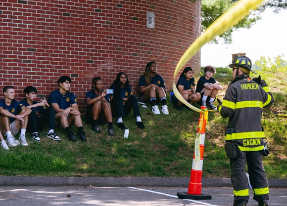 Firefighter stands in front of Hamden students
