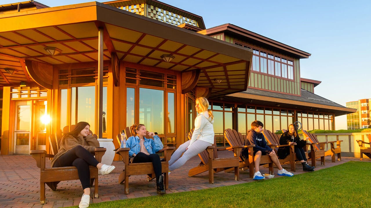 Students watch the sun set on Quinnipiac's York Hill Campus