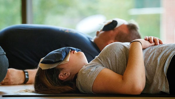 Student rests peacefully laying down in a group fitness class in the RecWell Center