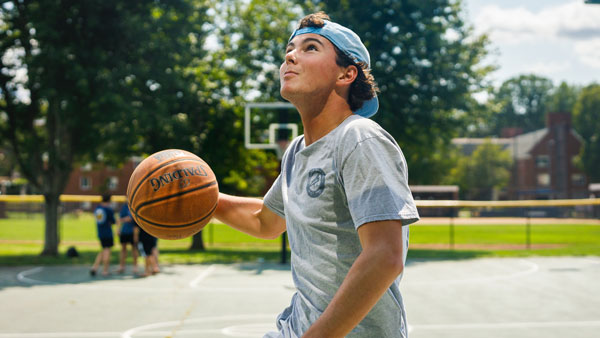 Student holding a basketball while playing on the Mount Carmel courts