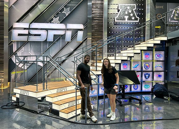 Students Julia Merolle and Jordan Steward smiling on set of ESPN