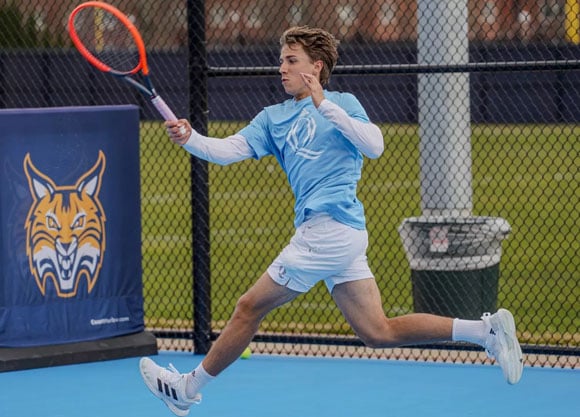 Quinnipiac tennis player swings racket while hitting tennis ball