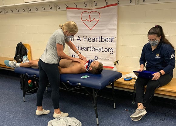 Two women perform an examination on  a patient.