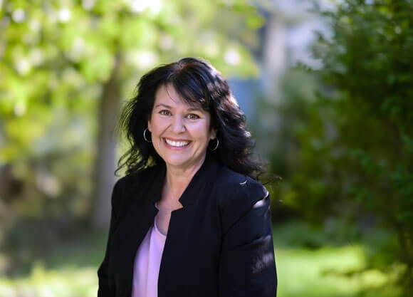 Headshot of Elizabeth Beaton with greenery in the background