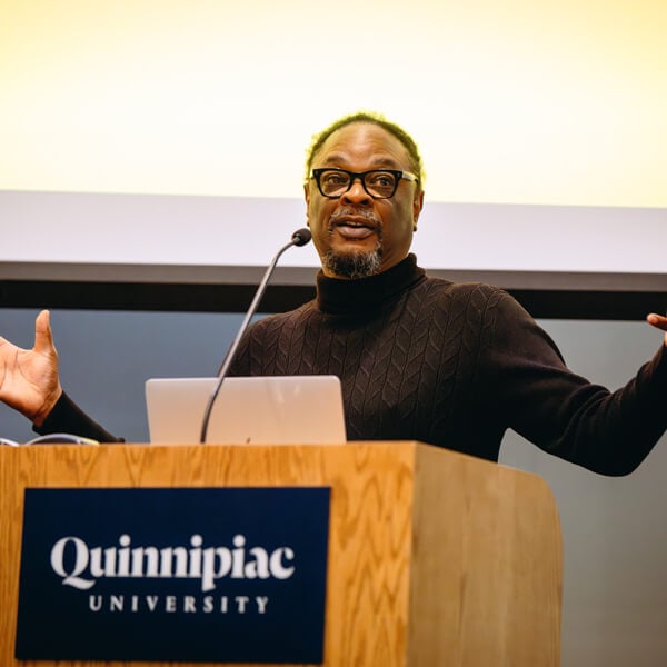 Lawrence Ross speaks at a podium in the Mount Carmel Auditorium