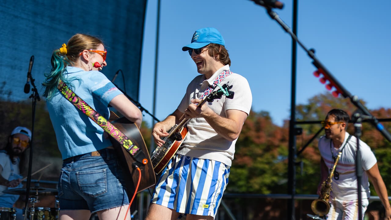 Two people play the guitar on stage