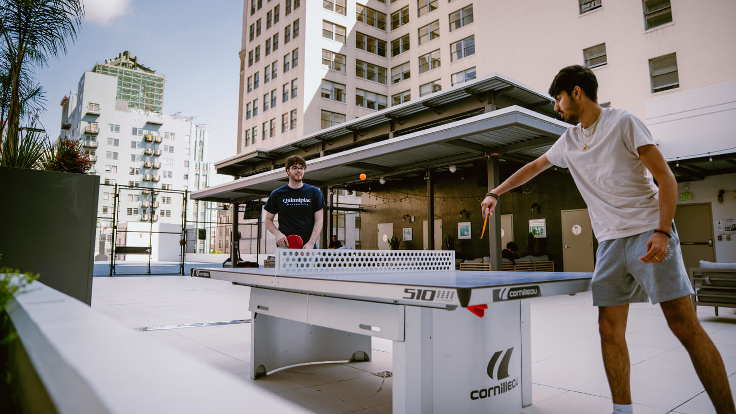 Two students play table tennis on the rooftop of a hotel in Los Angeles