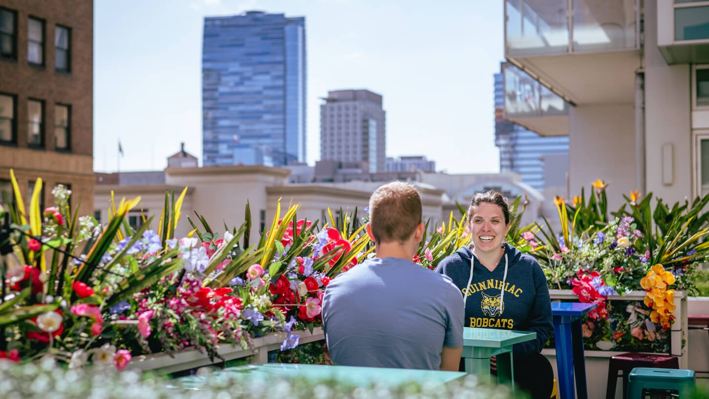 Two students sit at an outdoor table on a hotel rooftop in Los Angeles.